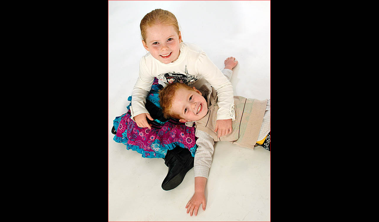 Young children cuddling on floor