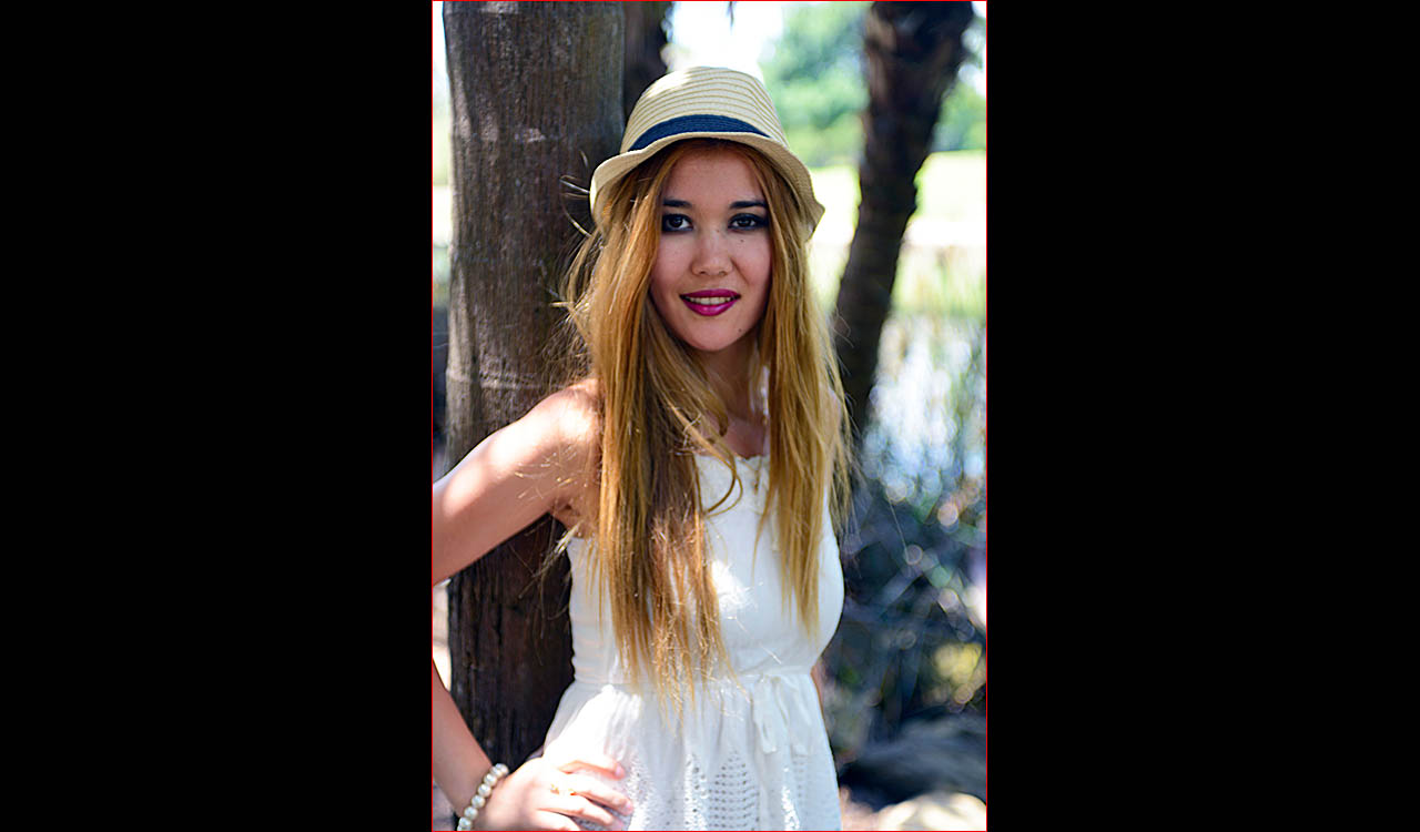 Young model outoor scene wearing white dress and hat