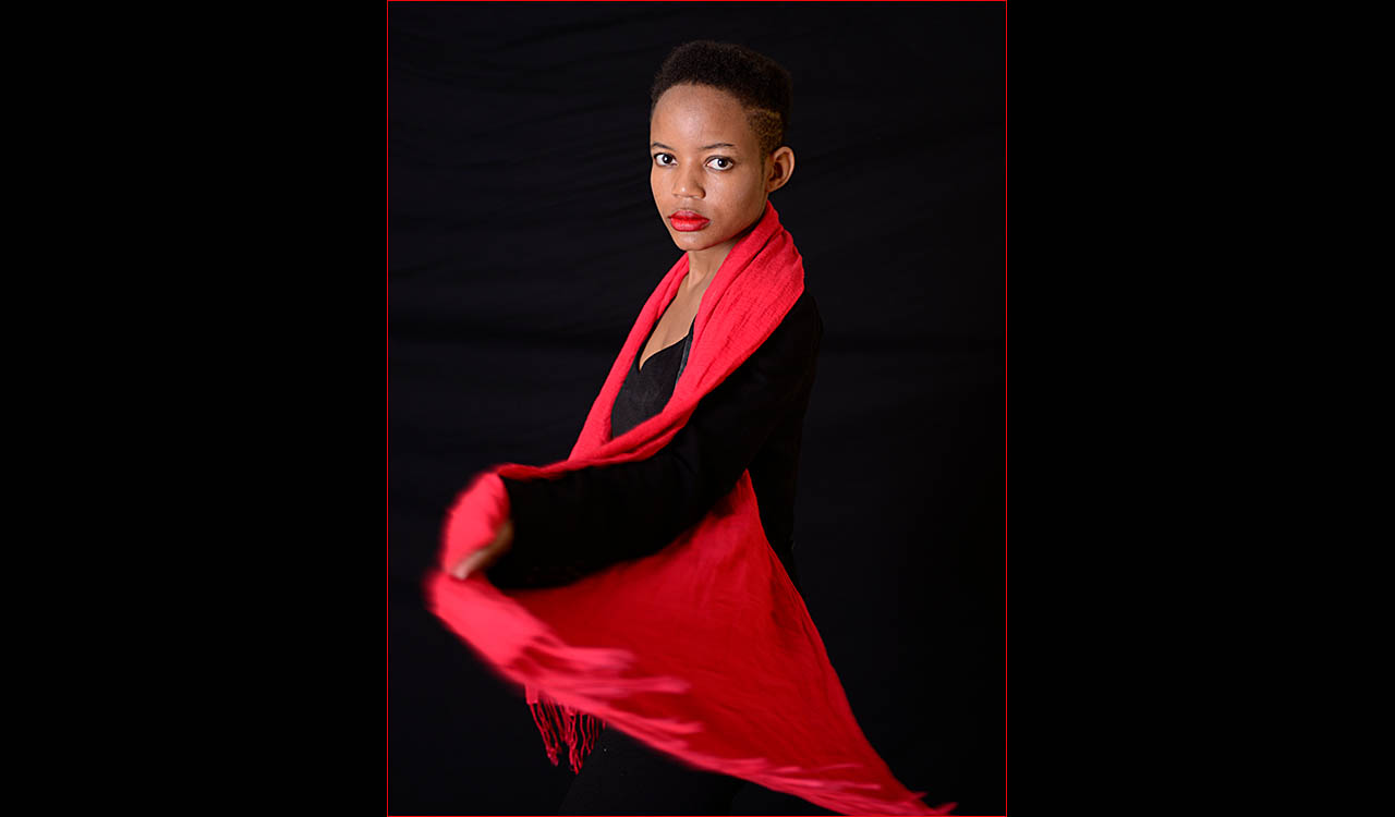 Simbi waring black cloths with red cape