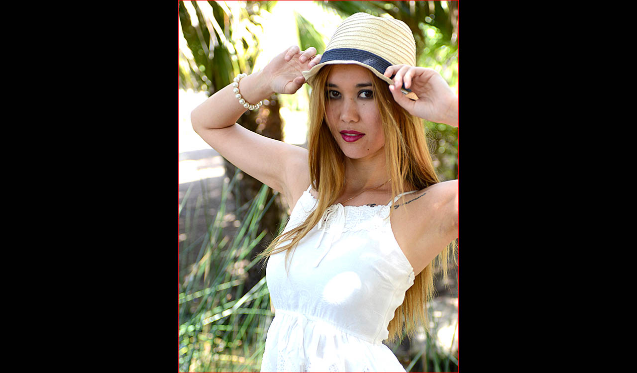 Attractive model outdoors wearing white sundree and hat